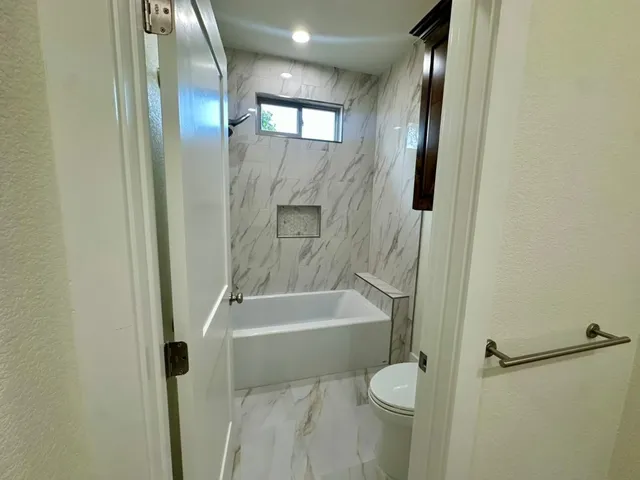 a bathroom with a toilet and a bathtub