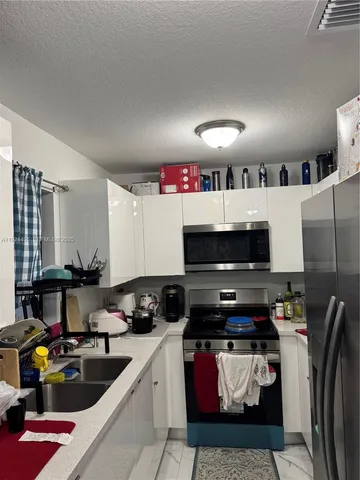 a kitchen with stainless steel appliances a stove a sink and a refrigerator