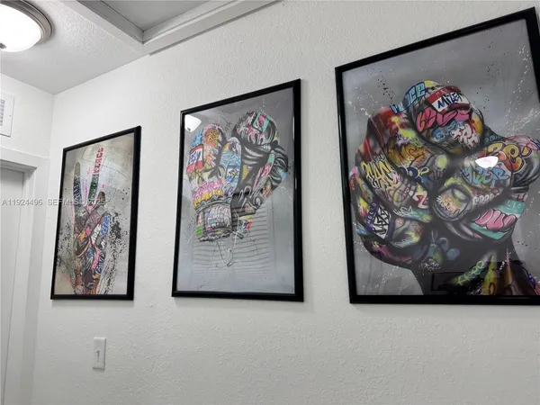 a white wall with paintings on the wall and a painting on the wall