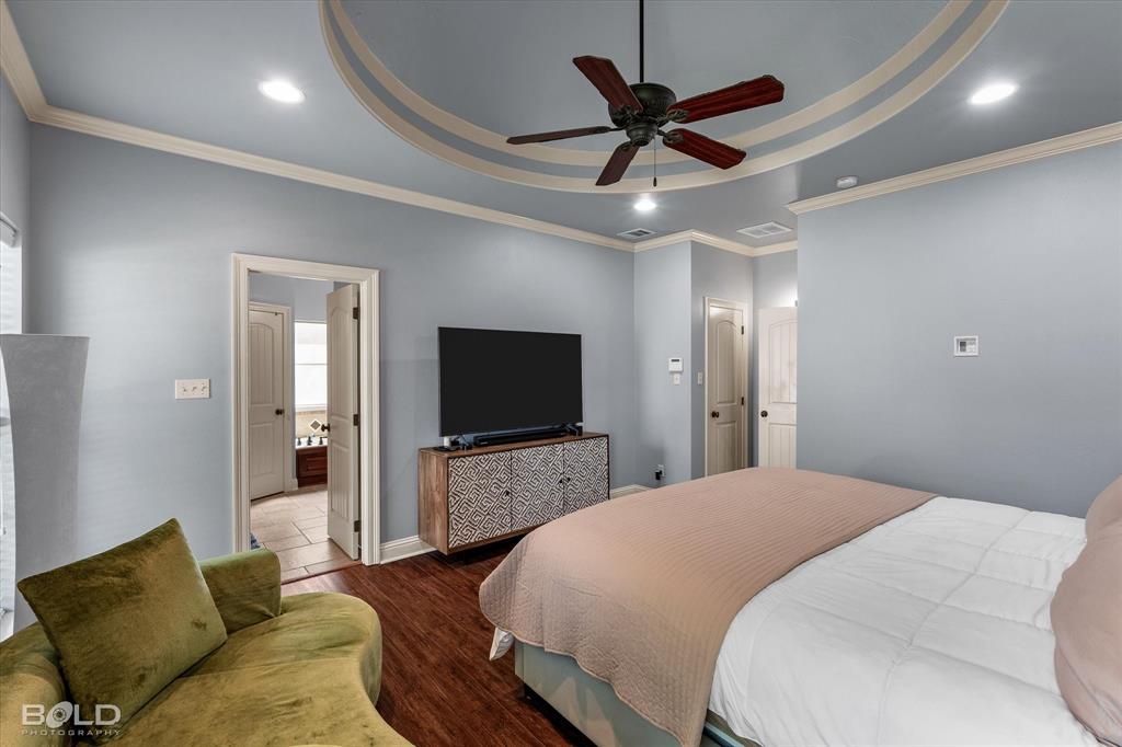 2220 Forest Hills Boulevard Haughton, LA 71037 - Photo 27 of 40 Tray ceiling with decorative trim and recessed lighting, ceiling fan, wood-finish flooring, and crown molding