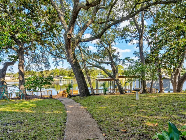 a view of swimming pool with large trees and a big yard