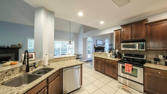 a kitchen with kitchen island granite countertop a sink stainless steel appliances and cabinets