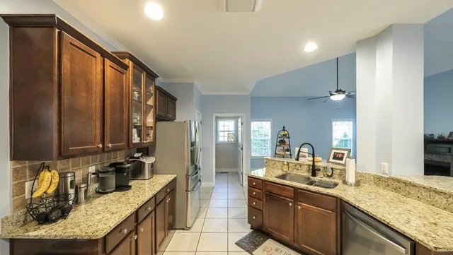 a large kitchen with granite countertop a sink and cabinets