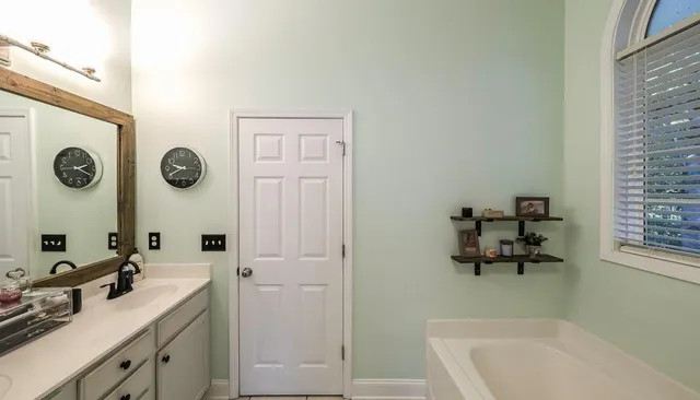 a bathroom with a tub a window and a shower
