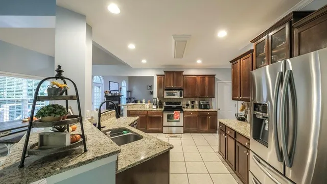 a kitchen with refrigerator a stove and a sink with wooden floor