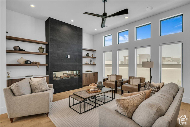 2761 West Lava Hls Road Santa Clara, UT 84765 - Photo 2 of 53 Living room featuring a tile fireplace, light wood-type flooring, recessed lighting, ceiling fan, and a towering ceiling