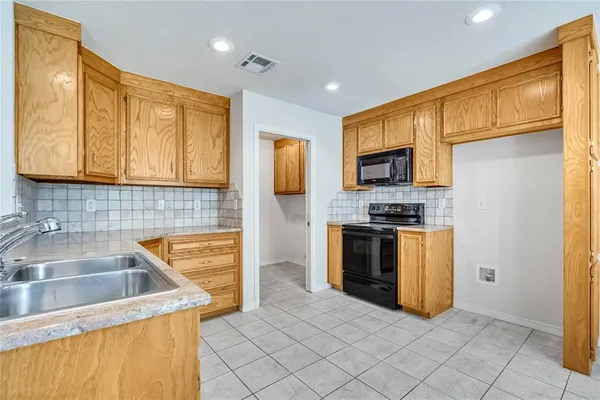 a kitchen with stainless steel appliances granite countertop a stove a sink and a microwave