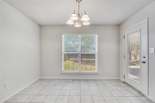 an empty room with windows and chandelier