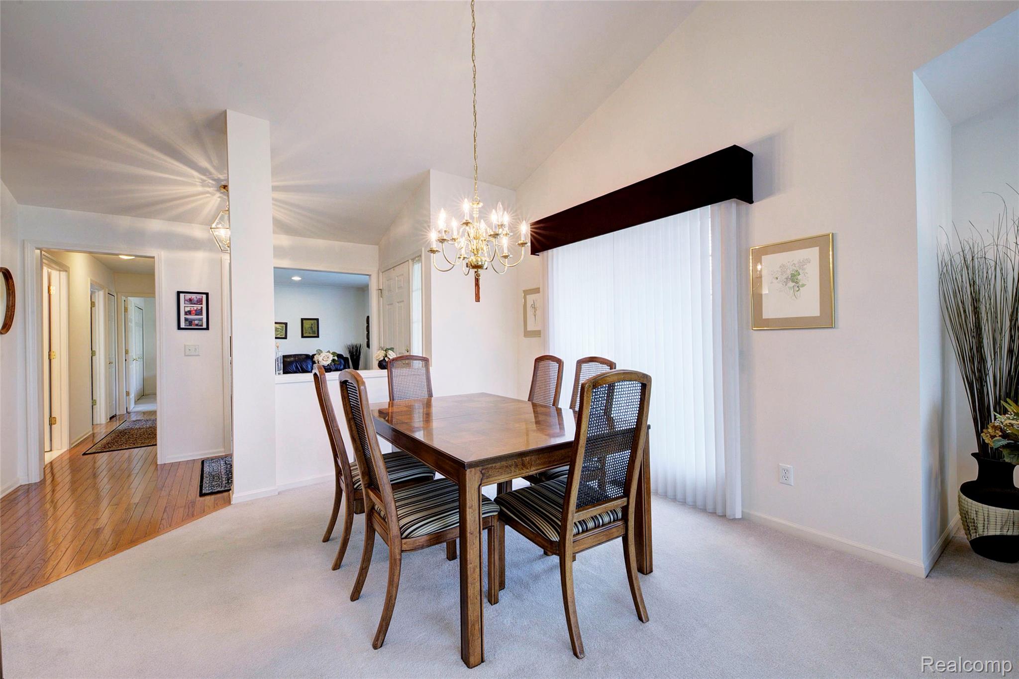 2577 Cleveland Way Canton, MI 48188 - Photo 9 of 34 Dining room featuring light carpet, a chandelier, and vaulted ceiling