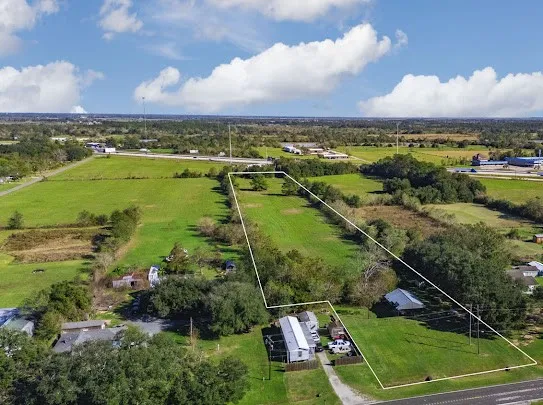 an aerial view of residential houses with outdoor space and lake view in back