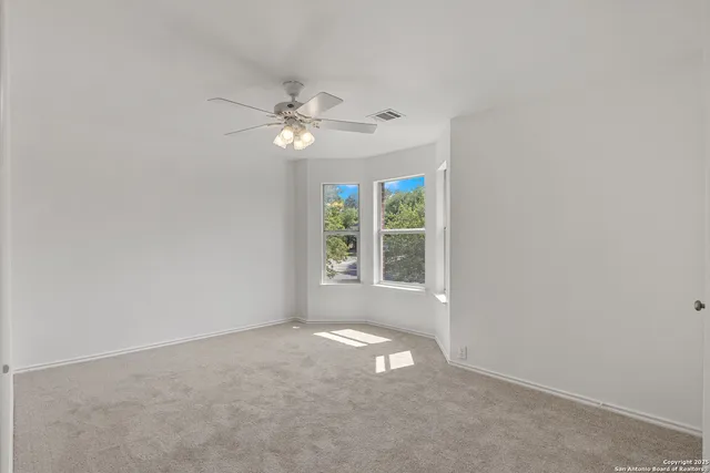 an empty room with a window and a fan