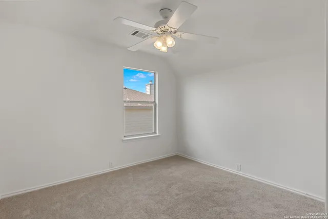 an empty room with windows and ceiling fan view