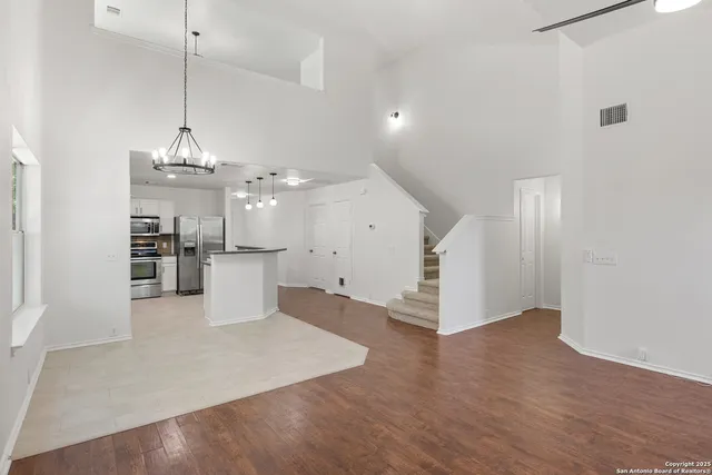 a view of a kitchen with refrigerator and wooden floor