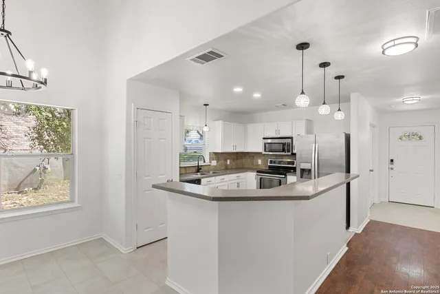 a kitchen with stainless steel appliances granite countertop a sink a stove and a refrigerator
