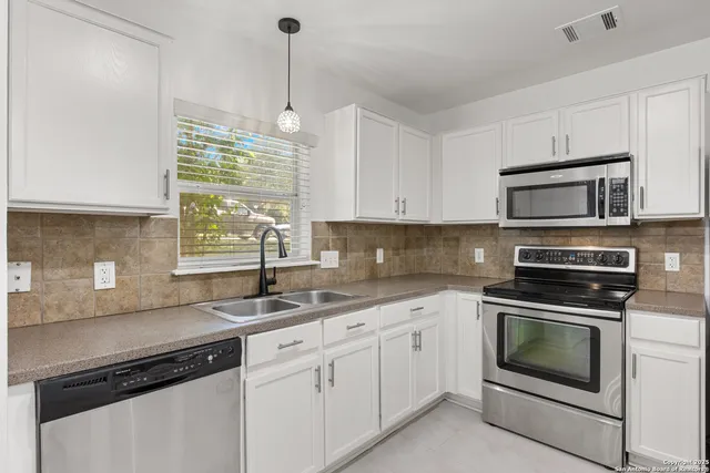 a kitchen with a sink stove and microwave