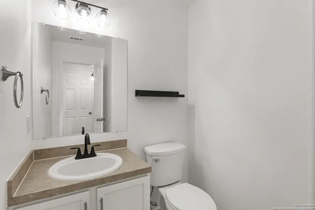 a bathroom with a toilet sink and mirror