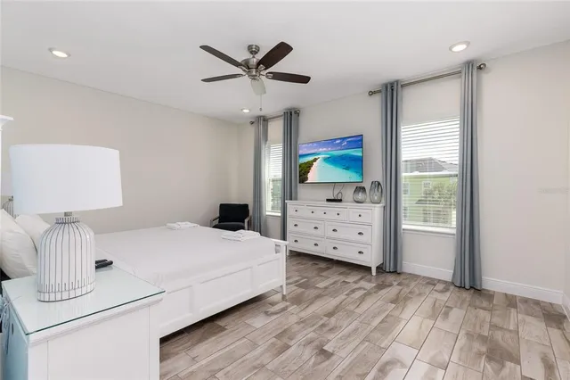 a bedroom with a bed and a ceiling fan