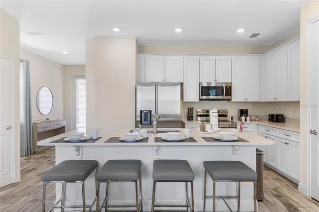a kitchen with granite countertop a sink and white cabinets