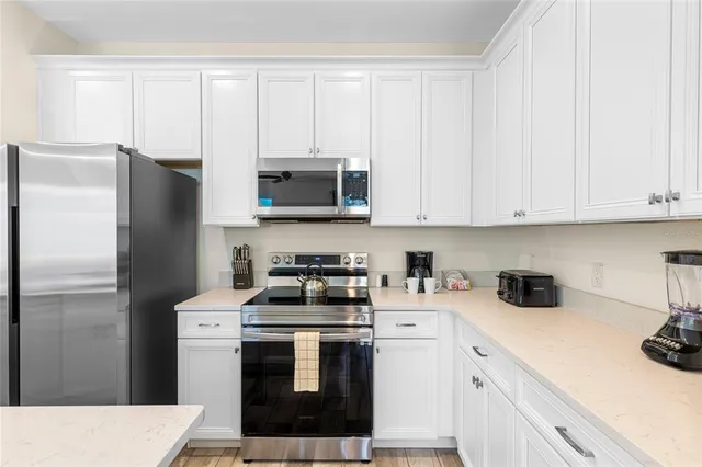a kitchen with stainless steel appliances white cabinets and a refrigerator
