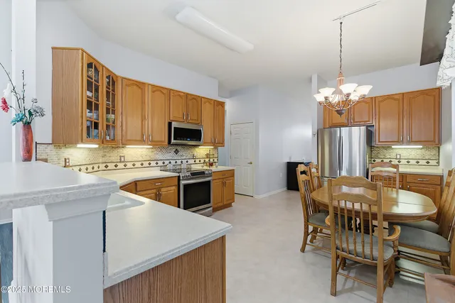 a view of a dining room with furniture a chandelier and a window