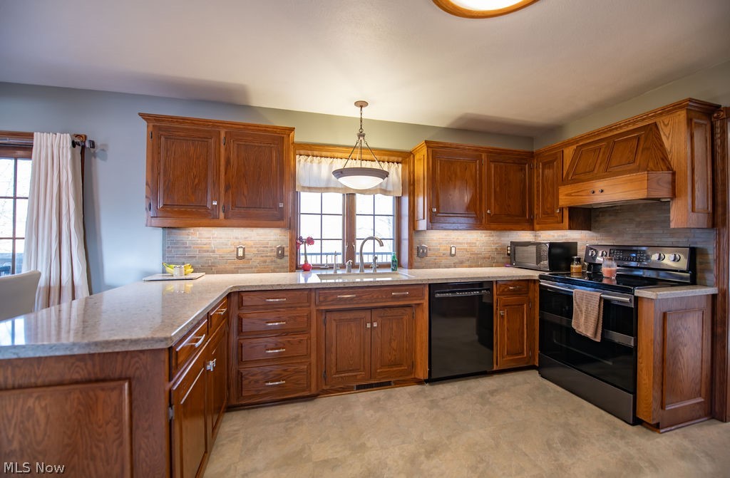 4848 Fette Road Dennison, OH 44621 - Photo 22 of 48 Kitchen with black appliances, a peninsula, wood finish cabinetry, backsplash, and decorative light fixtures