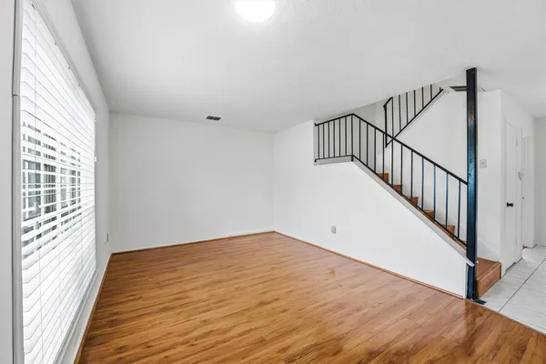 a view of a room with wooden floor and windows