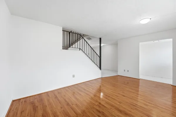 a view of a room with wooden floor and white walls