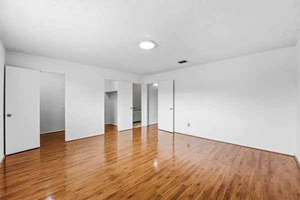 a view of an empty room with wooden floor