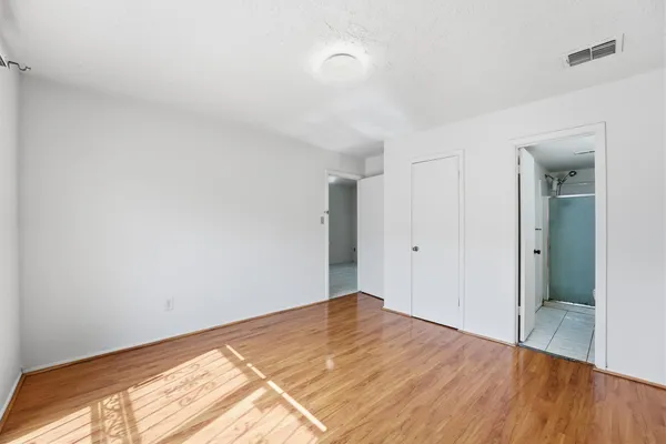 a view of a room has wooden floor and white walls