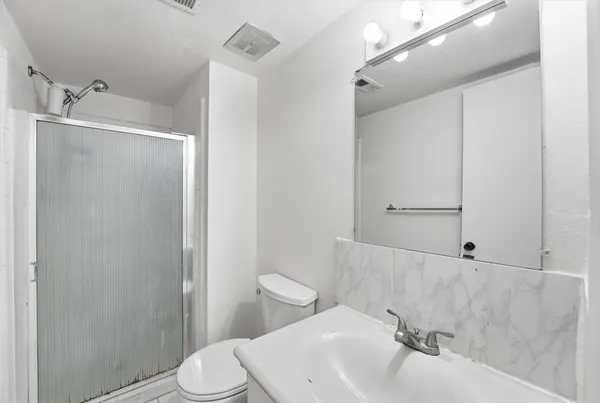 a bathroom with a sink a toilet and shower