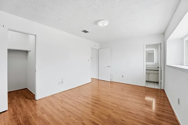 a view of a room with wooden floor and white walls