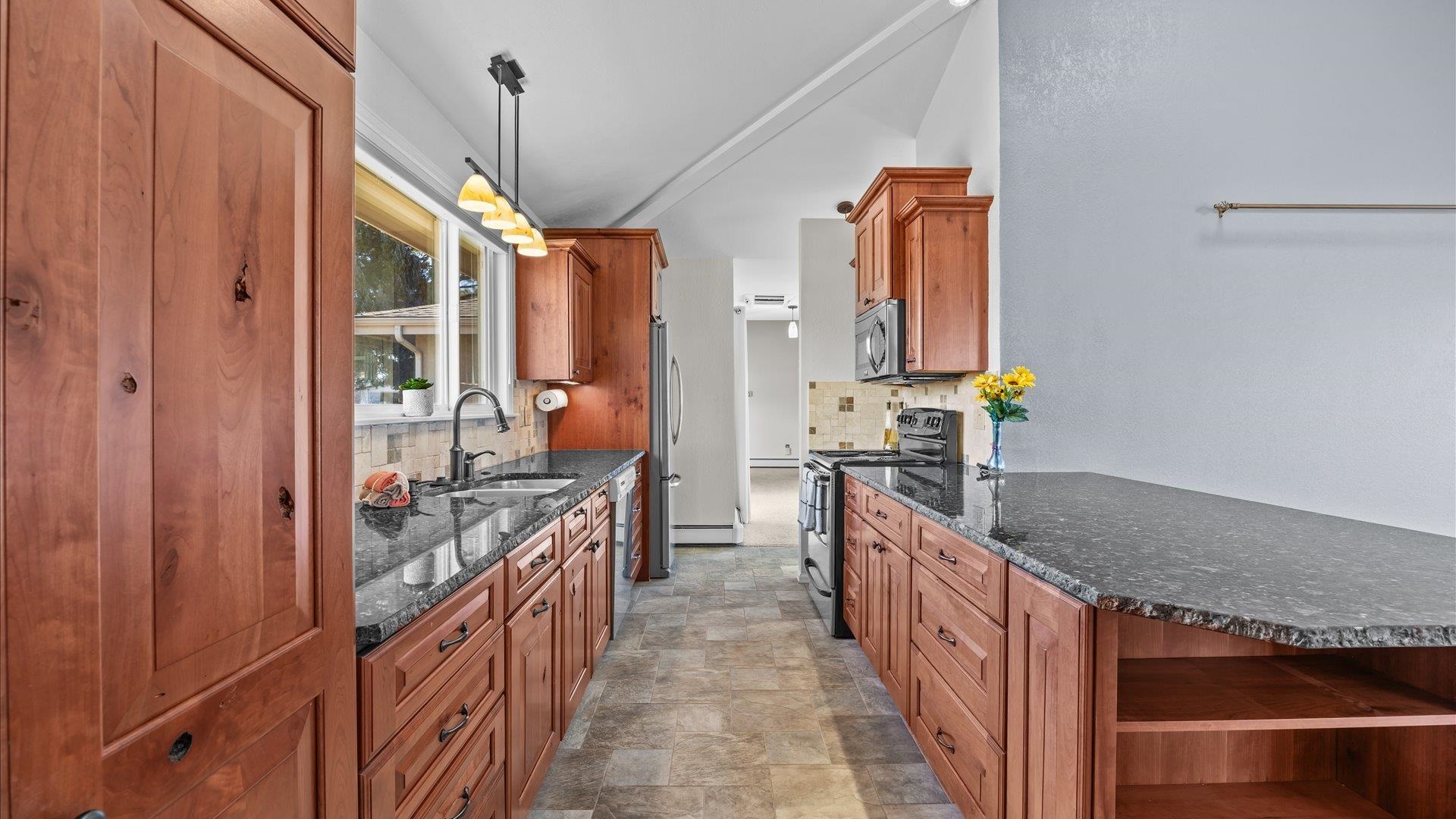 2262 Tanglewood Road Grand Junction, CO 81507 - Photo 9 of 27 a kitchen with stainless steel appliances granite countertop a stove and cabinets