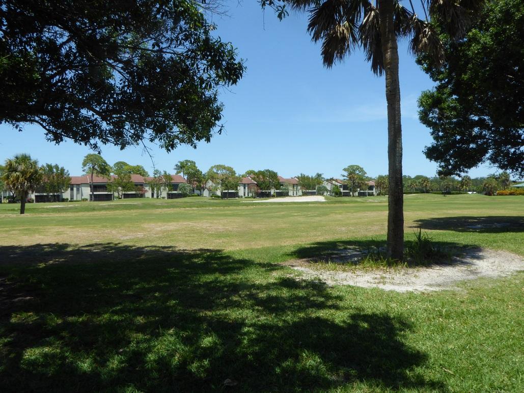 602 Pinecrest Circle, Unit B Jupiter, FL 33458 - Photo 16 of 19 a view of a grassy field with benches and trees all around