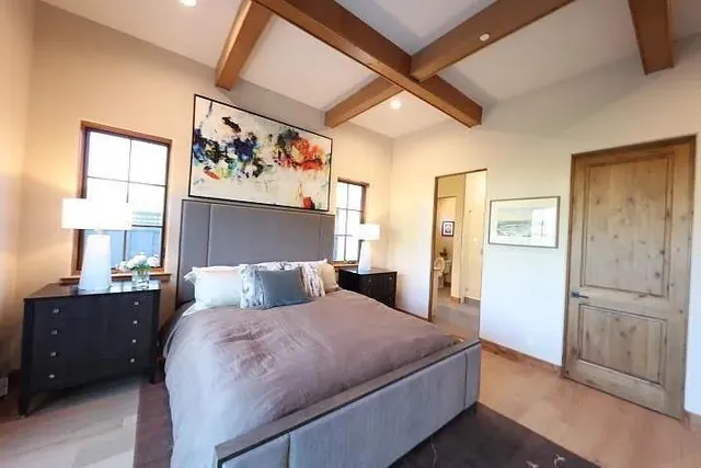 a bedroom with a bed and a painting on the wall