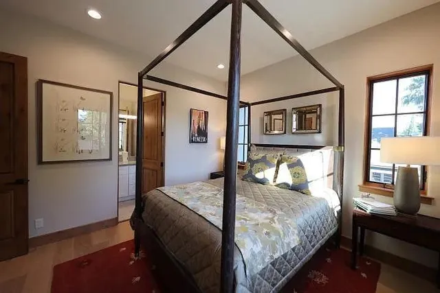 a bedroom with a bed mirror and a window