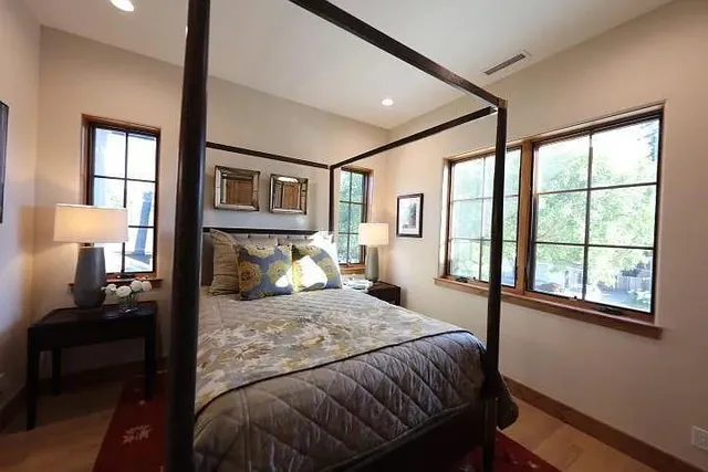 a bedroom with a bed wooden floor and window