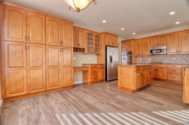 a kitchen with stainless steel appliances granite countertop a refrigerator a sink and a stove