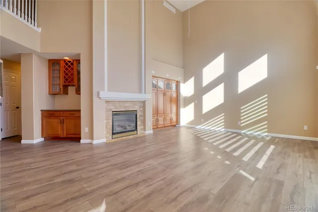 a view of empty room with wooden floor and fireplace