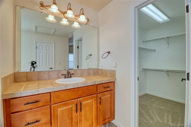 a bathroom with a granite countertop sink a large mirror and a shower