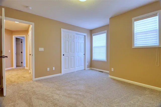 an empty room with windows and closet