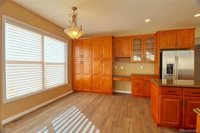 a view of a kitchen with wooden floor and electronic appliances
