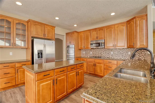 a kitchen with stainless steel appliances granite countertop a sink stove and refrigerator