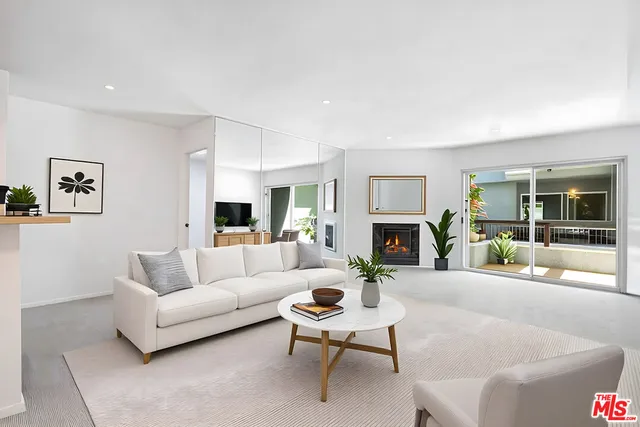 a living room with furniture a fireplace and a large window