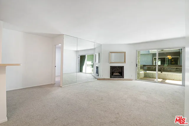 a view of an empty room with a fireplace and a window