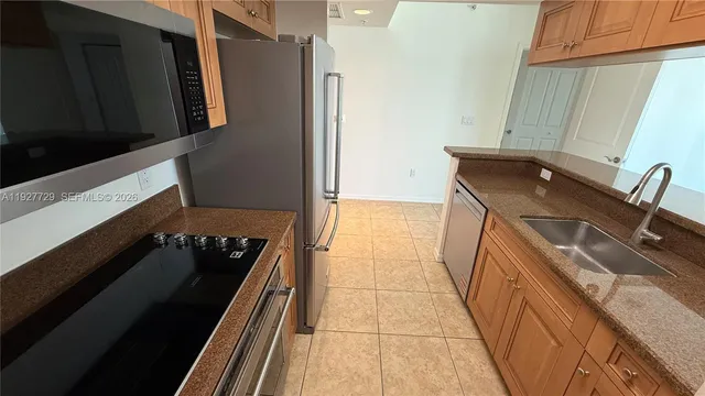 a kitchen with granite countertop a refrigerator stove and microwave