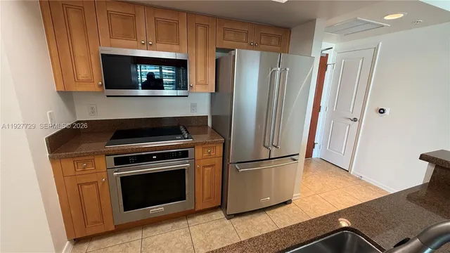 a kitchen with stainless steel appliances granite countertop a refrigerator and a sink