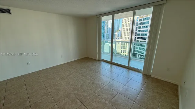 an empty room with a bathroom and mirror