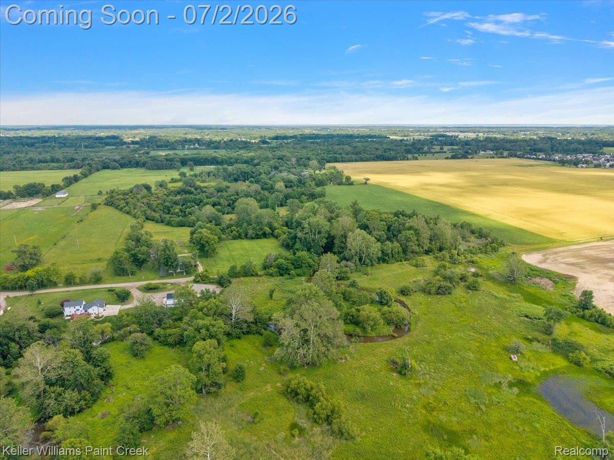 54230 Card Road Macomb, MI 48042 - Photo 30 of 73 Expansive property featuring varied terrain, including open fields, wooded areas, and a visible water feature