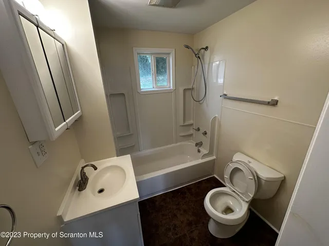 a bathroom with a tub sink and toilet