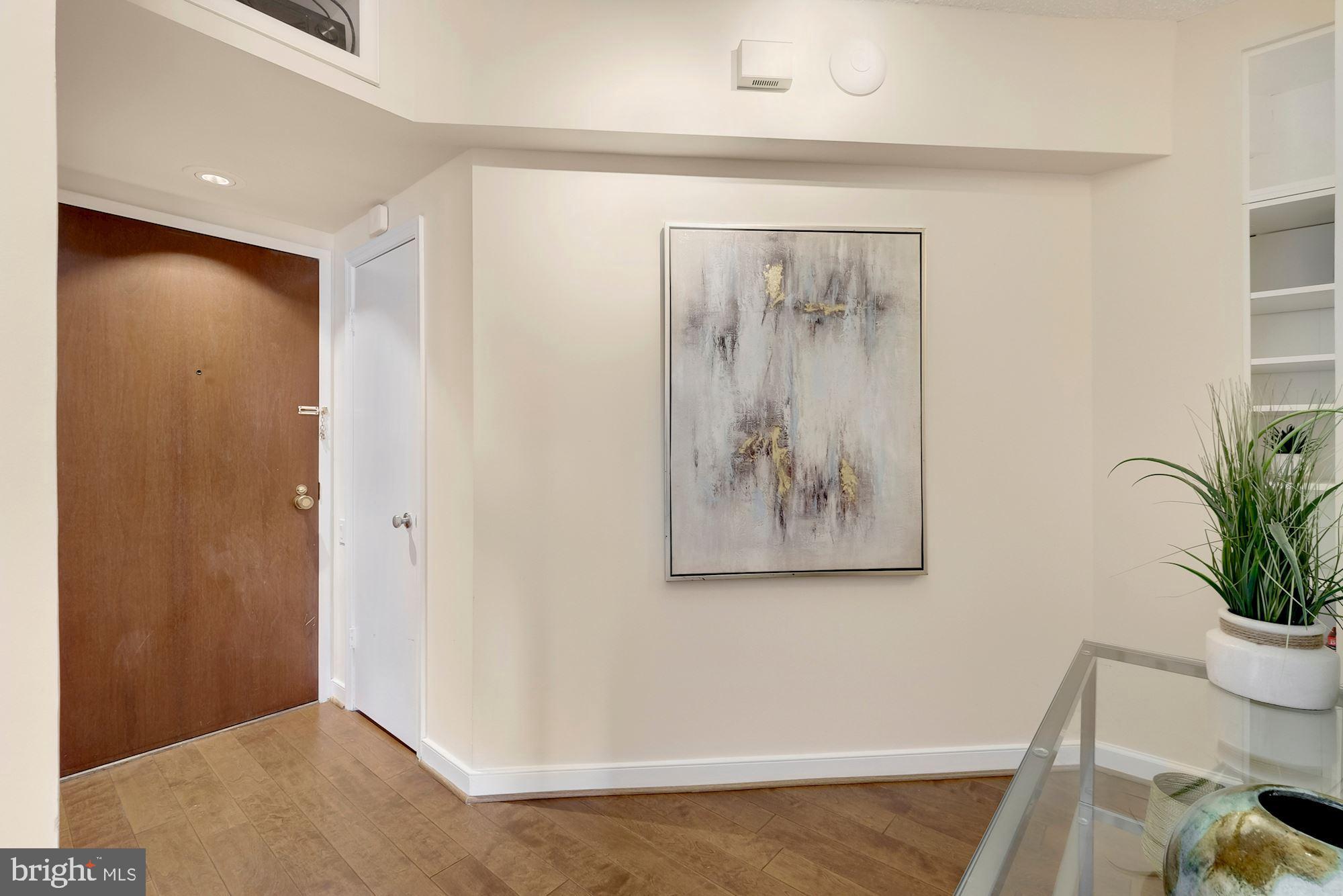 955 26th Street Northwest, Unit 707 Washington, DC 20037 - Photo 4 of 20 a view of a hallway with wooden floor and a potted plant